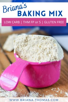 a pink bowl filled with white flour on top of a wooden table