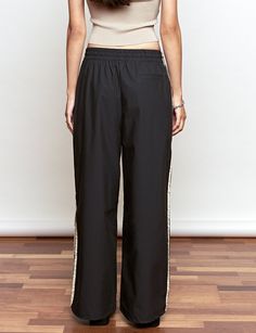 FINAL SALEBlack side stripe track pants with drawstring waist pull and wide leg .70% cotton, 30% nylonElastic encased waistbandSide pockets Size S waist 26-30", hips 38" Size M waist 27-31", hips 40"Total length 41"/104 cm Model is wearing a size small and model's height is 5.9"/175 cmImported Black Track Pants, Black Side, Side Stripe, Track Pants, Drawstring Waist, Wide Leg, Track, Pants, How To Wear