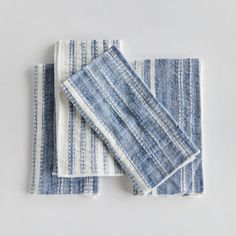 three blue and white striped napkins sitting on top of each other