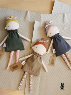 three dolls laying on top of brown paper