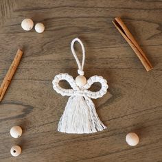 an ornament made out of yarn and wood beads on a table with cinnamon sticks