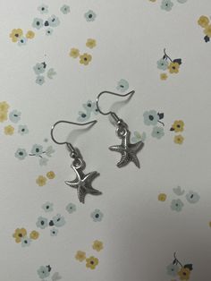 Starfish drop earrings with fish hook style closure. Nickel free. Elegant Star-shaped Summer Earrings, Star Jewelry With Lobster Clasp, Metal Starfish Jewelry, Star Shaped Earrings For Summer, Starfish Charm Dangle Jewelry, Star-shaped Earrings For The Beach, Summer Star-shaped Jewelry For Pierced Ears, Beach Earrings With Star Charm, Star Shaped Earrings With Star Charm For Beach