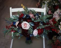 a bouquet of flowers sitting on top of a white chair next to another flower arrangement