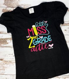 ANY GRADE, Little Miss 2nd Grade Cutie Shirt, Embroidered Back to School Shirt, 2nd Grade School Puffed Sleeve Shirt This design is available in black puffed sleeve shirt or a white puffed sleeve shirt. If you want just a plain shirt please message me as I do have them in stock as well. I use TOP Quality Shirts for embroidery. The Shirts are 100% cotton, they are VERY SOFT!! I have provided a sizing chart! HOW TO PURCHASE: 1. CHOOSE SIZE AND COLOR YOU WOULD NEED 2. CHOOSE GRADE YOU NEED 3. CLICK Cute Short Sleeve Tops With Machine Embroidery, Black Cotton Tops With Machine Embroidery, Embroidered Short Sleeve School Top, Embroidered Short Sleeve Top For School, Girl 2nd Birthday, Puff Sleeve Shirt, Elf Costume, Girls Graphic Tee, Plain Shirt