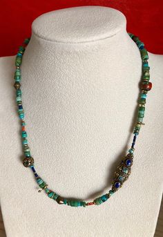 Eclectic Turquoise Necklace w/ handmade beads from Nepal. Largest bead is 1 1/4" x 3/8". Natural Vintage Inlaid Coral Bead. Common practice in Nepal was to fill the cracks and crevasses of old coral beads with bronze, turquoise, lapis and coral. These beads have become very rare and hard to find. Very unique necklace. I also mixed in a variety of other coral and brass beads. Brass Hook Clasp. Upon request I can custom make this necklace or any other necklace in my store longer. I will quote a pr Artisan Blue Necklace With Gemstone Beads, Artisan Blue Round Beads Gems And Cabochons, Artisan Blue Round Beads, Artisan Blue Beaded Necklaces With Gemstone Beads, Traditional Turquoise Oval Beads Jewelry, Blue Turquoise Round Beads Necklace For Festival, Traditional Handmade Turquoise Beads, Artisan Blue Beads For Jewelry Making, Artisan Blue Beaded Necklace With Natural Stones