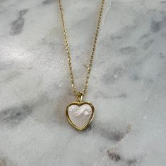 Heart necklace with white stone. It is 17 inches long and made of brass dipped in 18k gold. We ship across the US! White Plated Necklaces As Gift, White Plated Pendant Necklaces, Dainty Heart-shaped Brass Necklaces, White Plated Pendant Necklace, Heart-shaped Brass Necklace With Adjustable Chain, White Heart Pendant Necklaces For Everyday, Tarnish Resistant White Necklace For Gift, White Tarnish Resistant Necklace For Gift, Valentine's Day White Necklace With Pearl Pendant