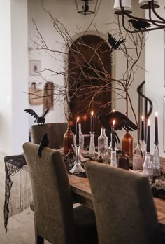 a dining room table with candles and birds on it