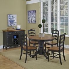 a dinning room table and chairs in front of windows