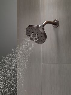 a shower head with water coming out of it's spout and running down the wall