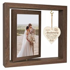 a wooden frame with an anniversary photo and a keychain hanging from the front