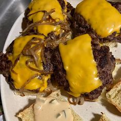 a white plate topped with two hamburgers covered in cheese