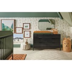 a baby's room with a dresser, crib and pictures on the wall