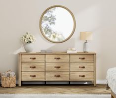 a bedroom with a bed, dresser and round mirror