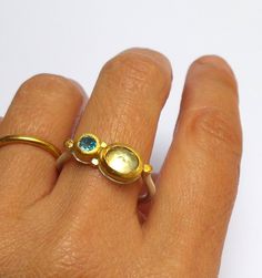 Citrine and Blue Topaz ring- Beautiful Citrine and Blue Topaz ring wrapped with 24 k solid gold decorated with 24 k gold dots . Round sterling silver band 2 mm wide in Matte finish. The Citrine stone size is 7/9 mm. The Blue Topaz stone size is 5 mm. The ring size is 9.5 US /61 U. The ring will be packed in a Beautiful gift box . Free Shipping!! Your item will be shipped via registered air mail with tracking number. Please contact me with any questions or requests. Noga Handmade Yellow Gold Moonstone Ring In Sterling Silver, Modern Gold Rings With Blue Topaz, Modern Gold Blue Topaz Ring, Rose Cut Sapphire Rings For Gifts, Topaz Birthstone Ring Jewelry, Modern Yellow Gold Jewelry With Blue Topaz, Yellow Gold Fusion Style Rings For Gift, Modern Yellow Gold Blue Topaz Jewelry, Gold Topaz Birthstone Ring In Sterling Silver