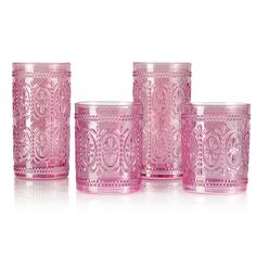 four pink glass tumblers sitting next to each other