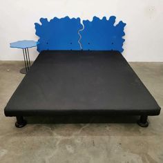 a black bed frame with blue paint on it