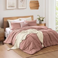 a bed in a bedroom with pink comforter and pillows