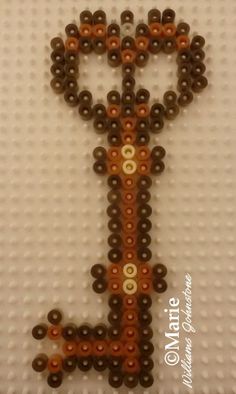 beaded letter h on white background with brown beads