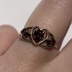 A charming vintage ring with three garnets and a heart detail to the center. Crafted in solid 9ct gold. Hallmarked. In excellent vintage condition. Professionally cleaned & polished.  Comes in a presentation box and will be sent Royal Mail Special Delivery. Refer to images for more information. Size: UK size I 1/2, US size 4 1/2. Weight: 1.4 grams. Vintage Gold Garnet Birthstone Ring, Vintage Birthstone Rings For Valentine's Day, Vintage Garnet Birthstone Ring For Anniversary, Vintage Garnet Birthstone Promise Ring, Vintage Heart Ring With Birthstone, Vintage Heart Cut Birthstone Ring, Vintage Heart Cut Birthstone Heart Ring, Vintage Heart Ring With Birthstone For Valentine's Day, Vintage Garnet Ring