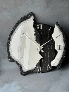 a black and white clock with the face of a broken piece of glass on it