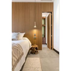 a bed sitting next to a wooden wall in a bedroom on top of a rug