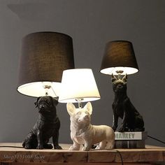 two lamps with dogs on them sitting next to each other and one lamp has a dog figurine underneath it