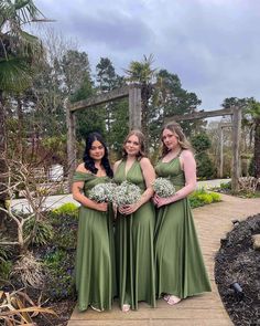 three bridesmaids in green dresses posing for the camera