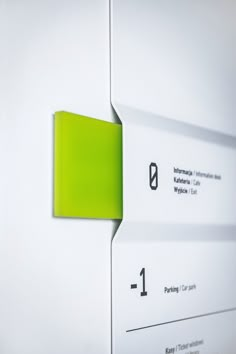 a green piece of paper stuck to the side of a white wall