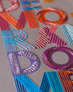 the letters are made out of strips of colored paper