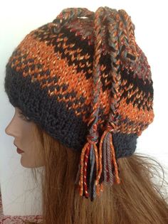 a knitted hat with tassels is shown on a mannequin head