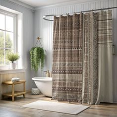 a bathroom with a tub, shower curtain and rugs on the floor in front of it