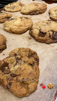 chocolate chip cookies are lined up on a baking sheet