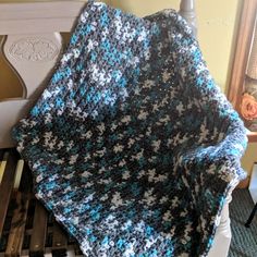 a crocheted blanket sitting on top of a chair