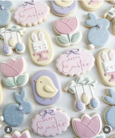 decorated cookies are arranged on a table for a celebration or baby shower, with the words happy easter written in cursive writing