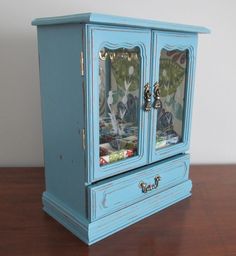 a blue cabinet with glass doors on top of a wooden table