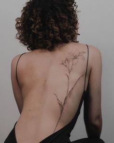 a woman's back with a flower tattoo on it