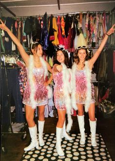 three girls dressed up in costumes posing for the camera