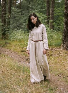 "This early medieval linen dress is universal for the Vikings and Slavs or any other reenactors. Based on medieval iconography and archaeological finds from Europe. Imagine how you walk around the field, and then go to the forest to collect wild apples to return home with sweets, where your family is waiting for you. And you can do all this in our dress. Soaked in the history of Slavs and Scandinavians, the dress is perfect for any time of the year. And, of course, perfect for you. The dress has Medieval Style Dresses For Festivals, Peasant Dresses For Medieval Festivals, Bohemian Medieval Dress For Festival, Peasant Dresses For Larp, Medieval Long Sleeve Linen Dress For Larp, Medieval Long Sleeve Linen Dresses, Peasant Style Long Sleeve Linen Dress, Bohemian Dresses For Larp, Peasant Style Medieval Linen Dress For Larp