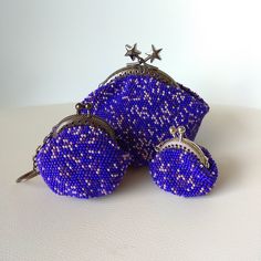 two purple purses with silver stars on them sitting next to each other in front of a white background