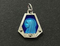 A nice vintage French Lourdes two toned blue enamel pendant/charm.  The base is a silver plate with a center two toned Lourdes with Marcasite bead accents.  Beautiful style.  Vintage catholic blue enamel medal.  Nice piece to add to your collection. It measures 1/2" tall x 1/2" wide In very good condition for its age.   Please visit our shop to view our entire vintage selection at OldSaltyShed: https://www.etsy.com/shop/OldSaltyShed?ref=hdr_shop_menu Thank you for shopping at OldSaltyShed! **Please Note:  All International orders do not include Custom Fee's, VAT Fee's or any other Fee/Tax your particular country requires. Blue Engraved Enamel Jewelry, Blue Enamel Engraved Jewelry, Blue Hallmarked Medallion Jewelry, Blue Engraved Enamel Necklaces, Blue Enamel Engraved Necklace, Vintage Blue Enamel Necklace, Vintage Charm Blue Jewelry For Jewelry Making, Collectible Blue Engraved Necklace, Blue Engraved Necklace Collectible