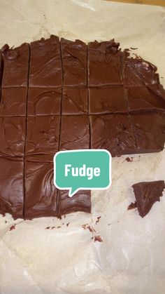 a chocolate fudge is cut into squares with a speech bubble above it that says fudge