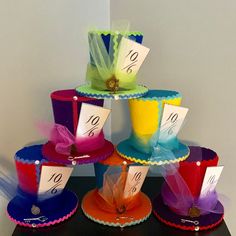 a stack of colorful hats with price tags on them and ribbons tied to the top