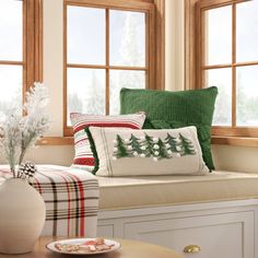 a window seat with pillows and christmas decorations