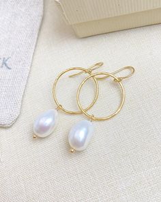 These earrings make it easy to achieve a chic laid-back style. Gold-filled circles are lightly hammered to achieve a faceted texture that reflects the light with every movement. The gold circles are adorned with large oval baroque pearls for a effortless elegance. The gold-filled ear wires are smooth and comfortable for all-day wear. Materials: 14k gold fill, cultured freshwater pearls Earring drop length: 1.5 inches Circle diameter: 3/4 inch Elegant Hammered Round Earrings, Elegant Hammered Drop Hoop Earrings, Elegant Hammered Everyday Earrings, Elegant Oval Hammered Earrings, 14k Gold Filled Elegant Jewelry, Elegant 14k Gold Filled Circle Jewelry, Elegant Hammered Hoop Earrings, Elegant Hammered Round Hoop Earrings, Elegant 14k Gold Filled Circle Hoop Earrings