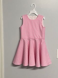 Beautiful  Barbie inspired pink gingham checked twirl dress..  The gingham fabric is Robert Kaufman  cotton.  The sleeveless dress has a fully lined bodice.  The back closes with kam Plastic  snaps.  The dress has a full circle twirl for that little dancer.    I would be happy to make this dress in other colors or fabric.  available in sizes 12 months to size 8  Measurements will be in the photo section A-line Plaid Dress For Picnic, Spring Plaid A-line Dresses, Spring Gingham A-line Dress, Cute Sleeveless Spring Plaid Dress, Fitted Pink Plaid Dress For Spring, Cute Sleeveless Plaid Dress, Sleeveless Houndstooth Dress For Spring, Cute Plaid Sleeveless Dress, Cute Pink Plaid Dress With Ruffles