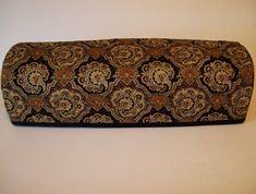 a large brown and black patterned pillow sitting on top of a white wall