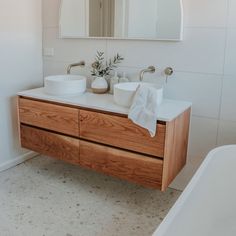 a bathroom with two sinks and a bathtub next to a mirror on the wall