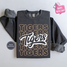 Tigers Sweatshirt, Tigers School Mascot Sweater, Tigers School Spirit Sweatshirts, Go Tigers Crewneck, Tigers Team Football Game Day Hoodie Our high-quality sweatshirts and hoodies come in a variety of sizes and colors to suit your needs. If you have any questions or special requests, please don't hesitate to contact us. We hope you enjoy browsing our shop and find something you love! FEATURES * Sizes Offered: Refer to the drop-down menu for available sizes. * Colors: See the drop-down menu and photos for options. * Material: Soft wash cotton-poly blend. * Style: Crewneck Sweatshirt or Hoodie * Care: Machine wash cold, delicate cycle inside out with like colors. Tumble dry low or hang to dry. * Graphic: Professionally printed using leading industry equipment. * Double needle stitched and p Team Ideas, Go Tigers, Tiger Team, School Spirit Shirts, Dress Up Day, Spirit Shirts, Swim Team, School Mascot, Football Game