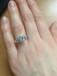 a woman's hand with an engagement ring on it