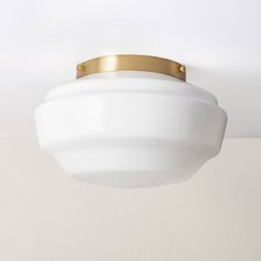 a white light hanging from the ceiling with a gold ring around it's edge